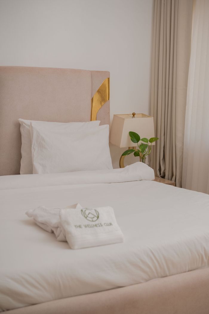 Elegant bedroom with plush beige headboard and luxurious bedding for a serene ambiance.