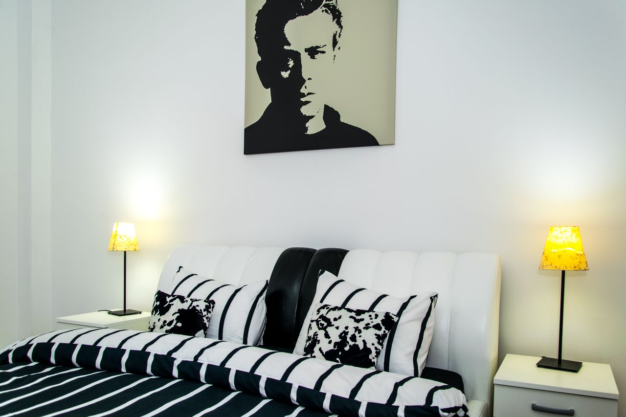 Contemporary bedroom featuring a stylish double bed, bedside tables, and modern artwork.